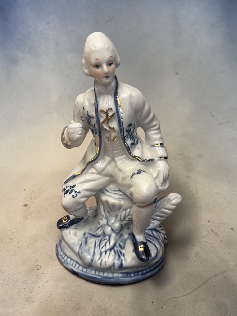 Vintage Blue and White Porcelain Colonial Man Sitting on a Tree Trunk